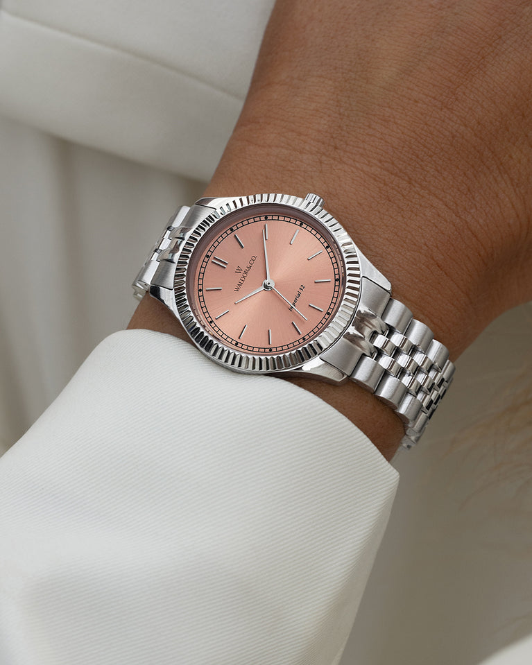 A round womens watch in silver from Waldor & Co. with salmon sunray dial and a second hand. Seiko movement. The model is Imperial 32 Positano 32mm.