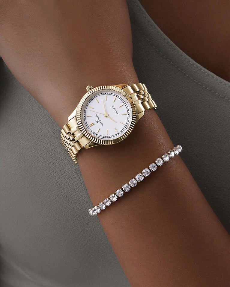 A round womens watch in 22k gold from Waldor & Co. with white sunray dial and a second hand. Seiko movement. The model is Imperial 32 Positano 32mm.
