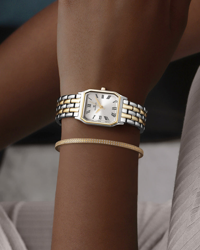 En fyrkantig damklocka i 22k guldpläterat 316L rostfritt stål från WALDOR & CO. med vit Diamond Cut Sapphire Crystal glass urtavla. Seiko urverk. Modellen är Eternal 22 Bellagio.