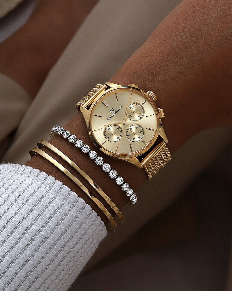 A round womens watch in 22k gold from Waldor & Co. with gold sunray dial and a second hand. Seiko movement. The model is Epoch 36 Formentera 36mm.
