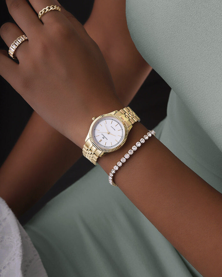 A round womens watch in 22k gold from Waldor & Co. with white sunray dial and a second hand. Seiko movement. The model is Imperial 32 Positano 32mm.