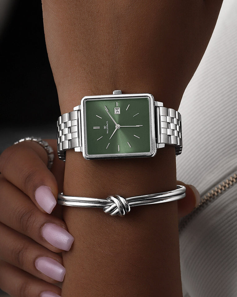 En fyrkantig damklocka i silver från WALDOR & CO. med grön sunray urtavla och en sekundvisare. Seiko urverk. Modellen är Delight 32 Chelsea 28x32mm.