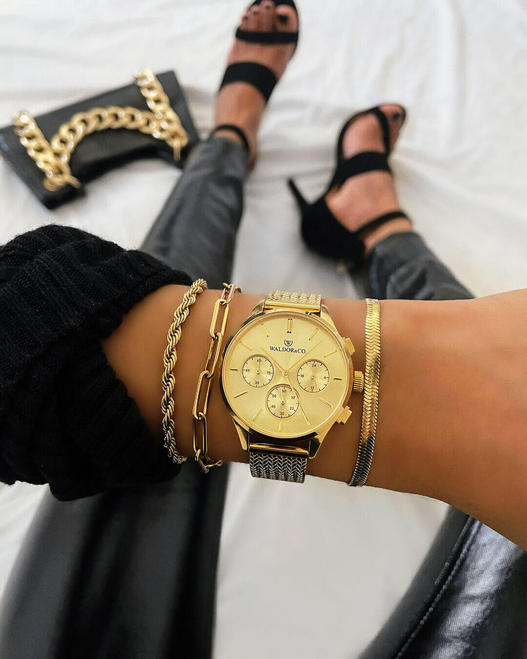 A round womens watch in 22k gold from Waldor & Co. with gold sunray dial and a second hand. Seiko movement. The model is Epoch 36 Formentera 36mm.