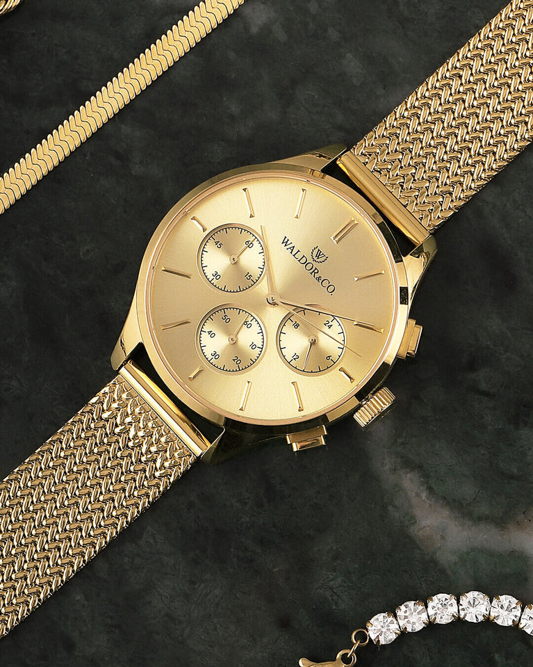 A round womens watch in 22k gold from Waldor & Co. with gold sunray dial and a second hand. Seiko movement. The model is Epoch 36 Formentera 36mm.